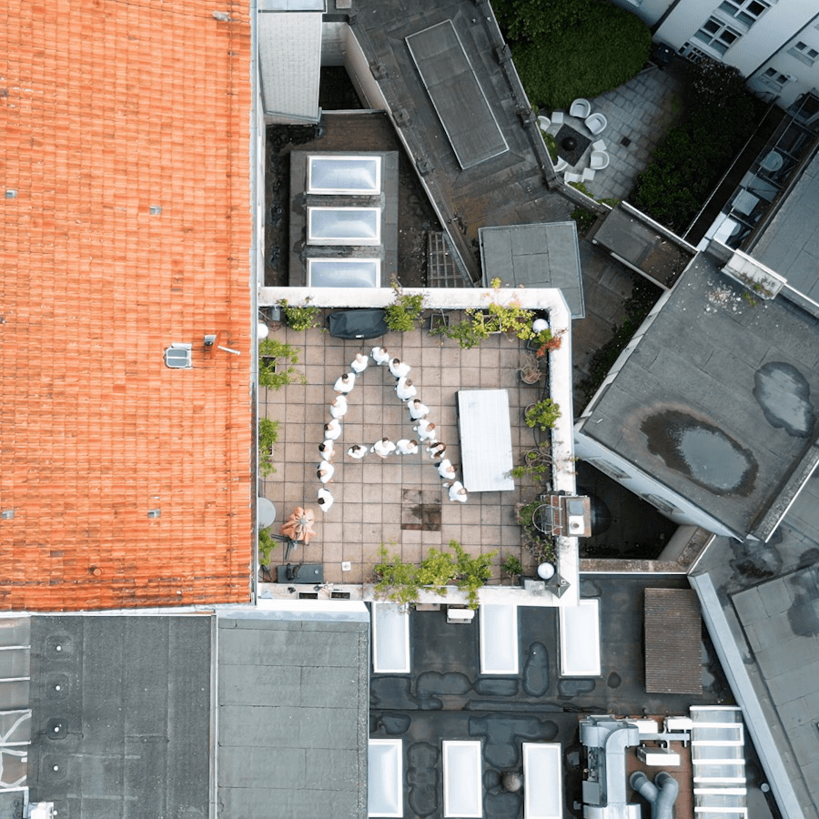 Luftbild der ATMINA-Dachterrasse in Hannover, das Team bildet ein großes A