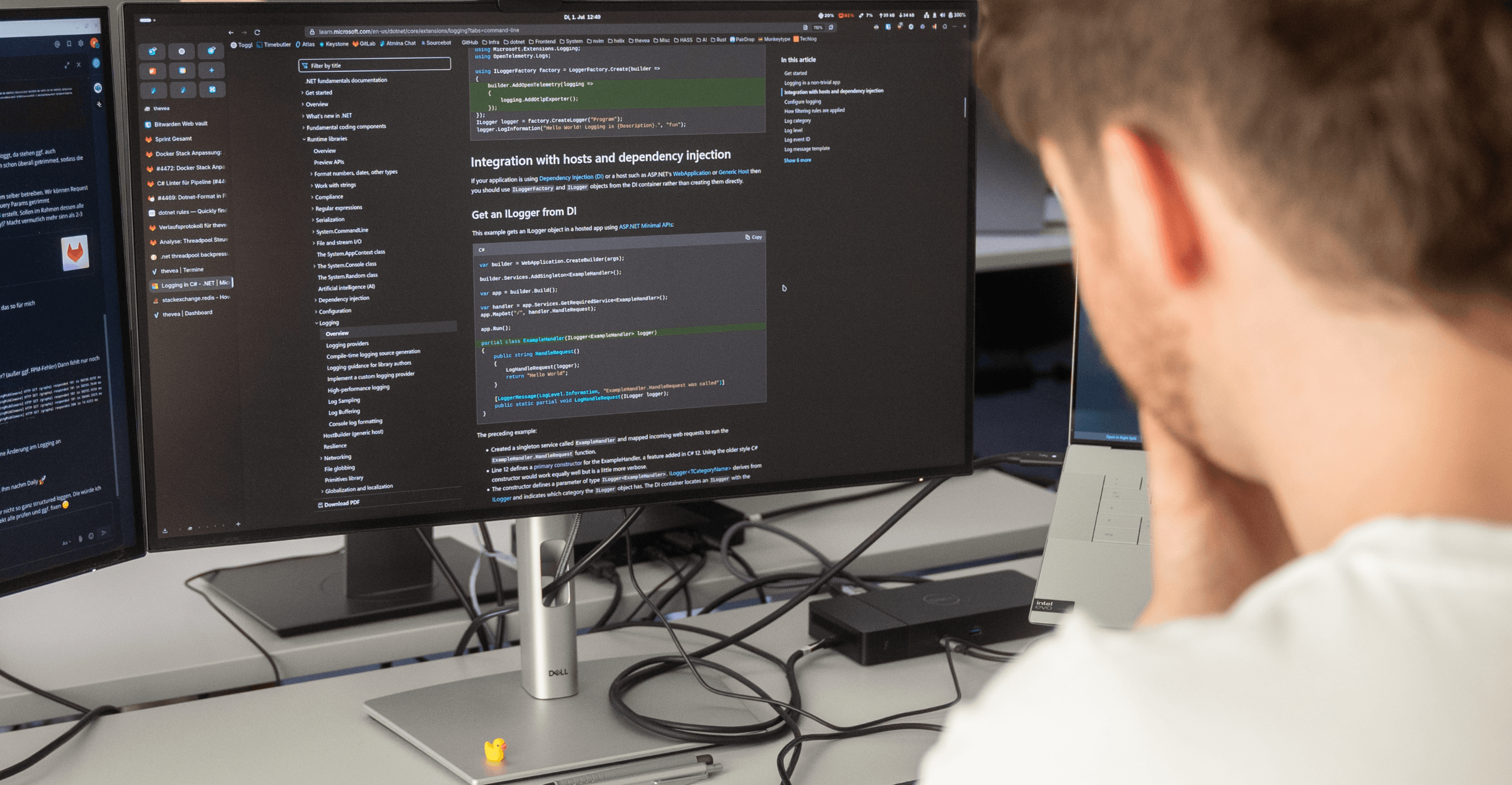 Entwickler am Monitor mit geöffnetem Code-Editor und Dokumentation